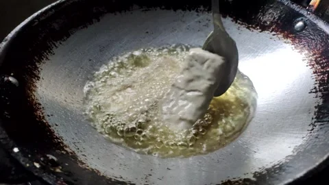 The Process of Deep-frying Tempeh Stock Footage 319723120