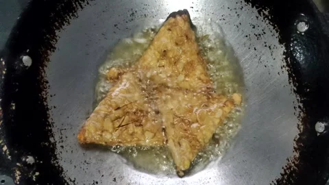 The Process of Deep-frying Tempeh Stockbeeldmateriaal 329398614