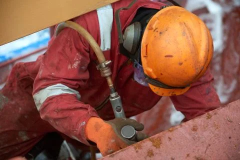 Process of derusting, paint and rust removal by pneumatic chisel from ship de Foto stock
