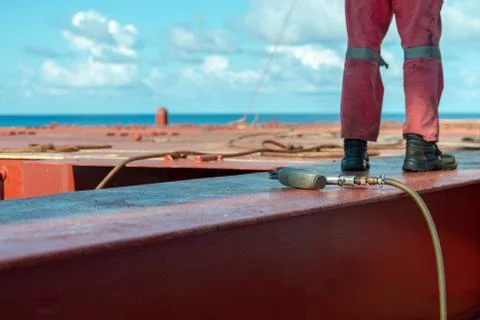 Process of derusting, paint and rust removal by pneumatic chisel from ship de Stock Photos