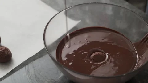 The process of dipping sweets in chocolate cream. Stock Footage 132865786