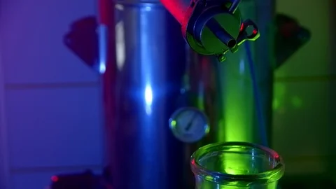 The process of distilling alcohol in the kitchen. Moonshine slowly drips into a Video stock 125905171