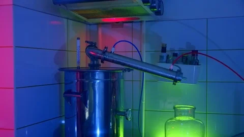 The process of distilling alcohol in the kitchen. Moonshine still stands on a Stock Footage 125905626