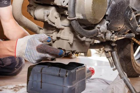 The process of draining oil from a motorcycle engine. Engine oil upgrade. Stock Photos