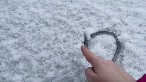 The process of drawing a heart by hand on the snow , Valentine's Day Stock Footage 328026099