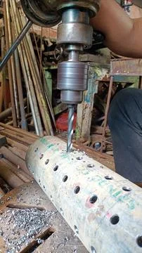 The process of drilling iron pipes. Stock Photos