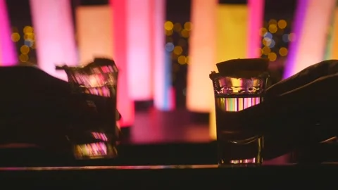 Process of drinking two silver tequila shots with lime with color changing led Stock Footage 153272143