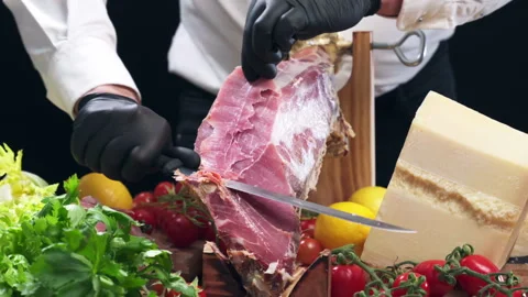 Process of dry-cured prosciutto leg slicing in luxury restaurant, person in Stock Footage 303059583