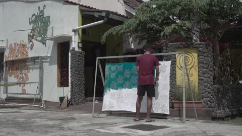 The process of dyeing the cloth that has been coated with wax (malam) with dye Stock Footage 146761084