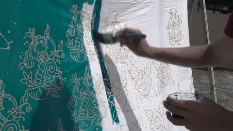 The process of dyeing the cloth that has been coated with wax (malam) with dye Stock Footage 146761138