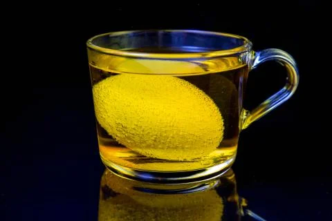 The process of dyeing eggs for Easter. egg in a transparent mug with dye. 스톡 사진