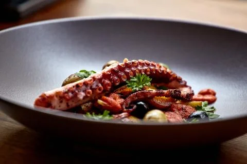 The process of eating the delicious grilled octopus. Stock Photos