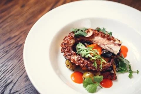 The process of eating the delicious grilled octopus.  Stock Photos