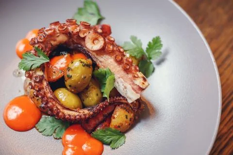 The process of eating the delicious grilled octopus. Stock Photos
