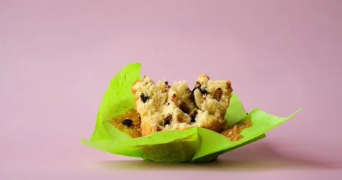 The process of eating a muffin in a green wrapper. 4K stop motion animation Video stock 236537590