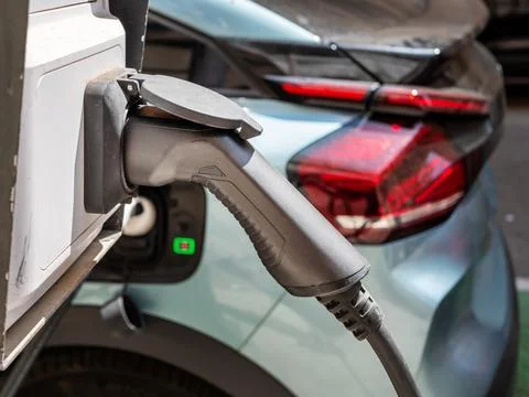 Process of electric car charging. charging cable handle on the background of Stock Photos