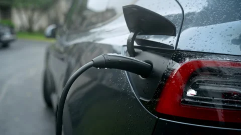 Process of Electric Car Charging at Home on a rainy day. Stock Footage 340383199