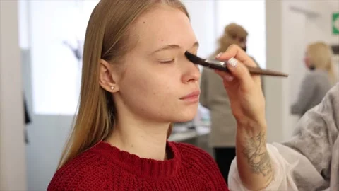 The process of face makeup brush alignment of the face tone on a beautiful young Stock Footage 149672003