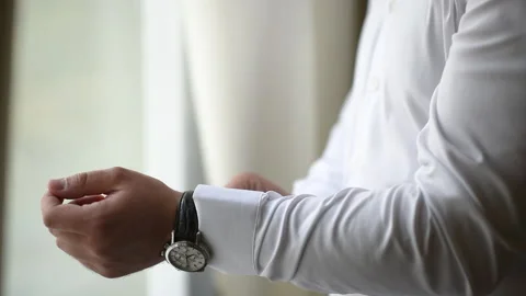 The process of fastening the button on the sleeve. A man fastens buttons on the 스톡 동영상 198673508