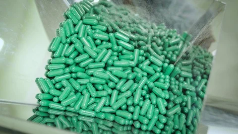 Process of filling the dust collecting machine with green hard shelled capsules Stock Footage 102459078
