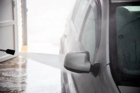 A process of flushing soap sud on silver car mirror with pressurised water Stock Photos