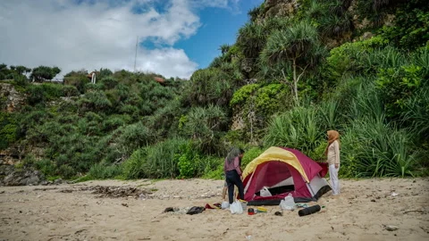 The process of folding a tent on the beach Stock Footage 168699919