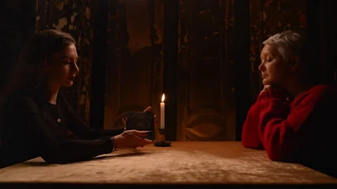 Process of fortune-telling with Tarot cards in dark room by light of burning Stock Footage 276334211