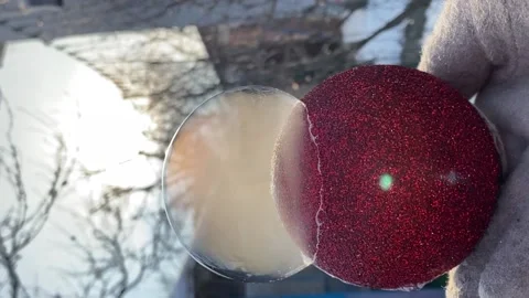 Process of freezing soap bubble in frost outside, on red New Year toy, in sun Stock Footage 220569116