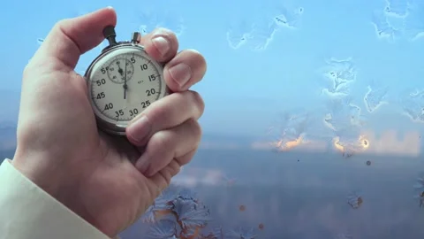 A process of freezing window in winter and stopwatch in a hand Stock Footage 235155758