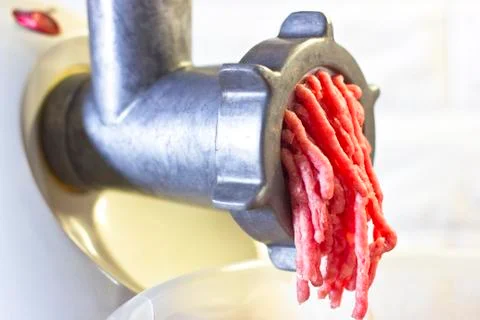 Process of fresh red meat grinding from mincing machine Stock Photos