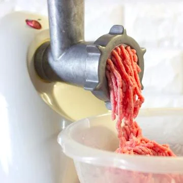 Process of fresh red meat grinding from mincing machine Foto stock
