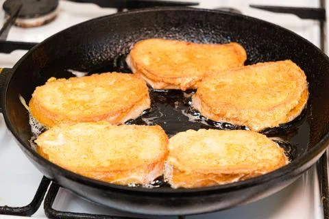 The process of frying bread croutons in an egg in a cast-iron skillet Stock Photos
