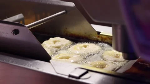 The process of frying donuts in an automatic deep fryer with oil Vídeo Stock 343681675
