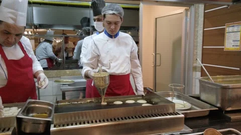 The process of frying pancakes and cheesecakes on a large hot stove in a rest Video stock 221852169