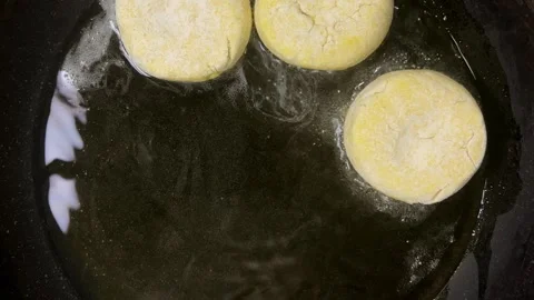 The process of frying syrniki in vegetable oil in a frying pan on the stove.  Stock Footage 301883595