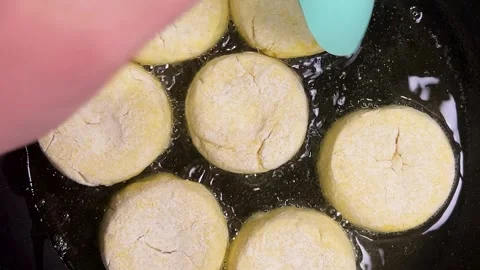 The process of frying syrniki in vegetable oil in a frying pan on the stove.  Stock Footage 301883983