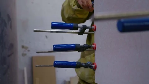 Process of glueing and tightening of two wooden board with steel clamps. 스톡 동영상 296542256