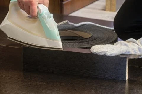 Process of gluing melamine edge to laminated chipboard sheet Stock Photos