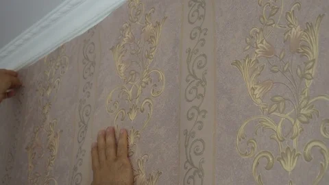 The process of gluing Wallpaper on the wall,the hand of the worker is smooth Stock Footage 79594778