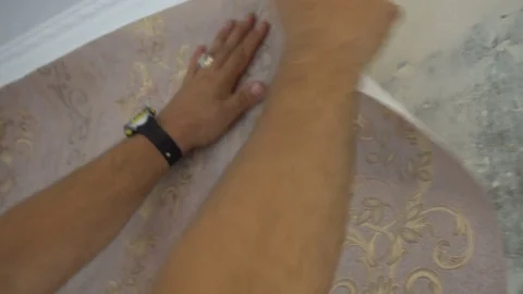 The process of gluing Wallpaper on the wall,the hand of the worker is smooth Stock Footage 79595085