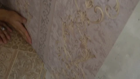 The process of gluing Wallpaper on the wall,the hand of the worker is smooth Stock Footage 79597302