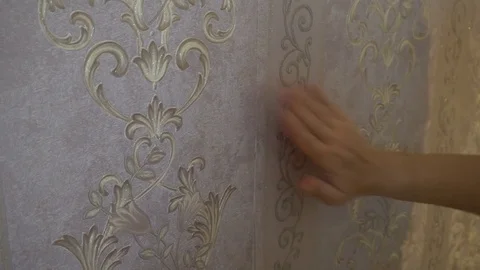 The process of gluing Wallpaper on the wall,the hand of the worker is smooth Stock Footage 79599331