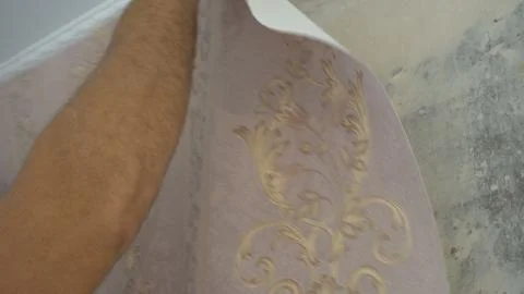 The process of gluing Wallpaper on the wall,the hand of the worker is smooth  Stock Photos