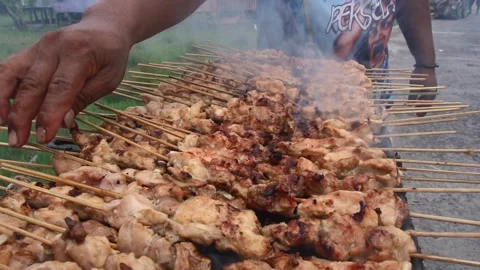 The process of grilling chicken satay over coals made of wood and coconut s.. Stock Footage 243573202
