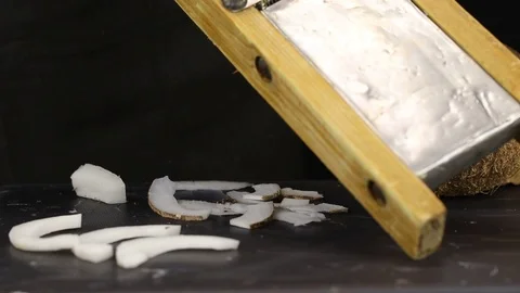 The process of grinding a piece of coconut Stock Footage 122371978