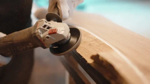 Process of grinding raw wood plank with angle grinder in workshop, flying wood Stock-Footage 266170195