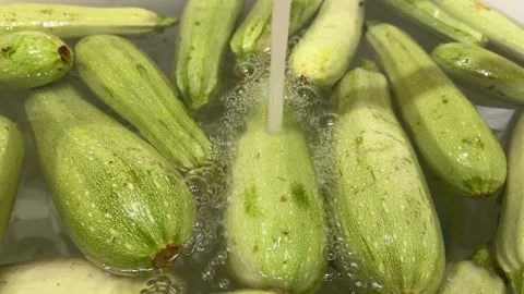 The process of harvesting and preparing zucchinis, showcasing washing, choppi Stock Footage 301864673