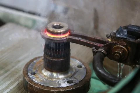 Process of heating and cooling metal. Hardening of steel part in production. Stock Photos