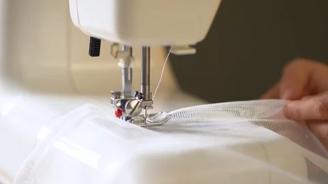 The process of hemming curtain edges from white mesh fabric. Stock Footage 125639594