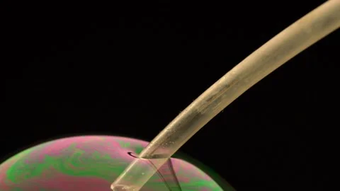 The process of inflating a soap bubble. Close-up. Shallow depth of field. Stock Footage 145066578